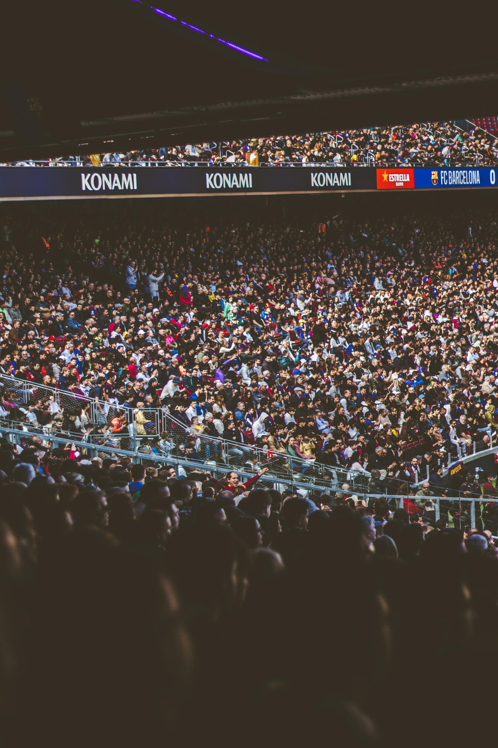 A packed football stadium with thousands of fans in the stands